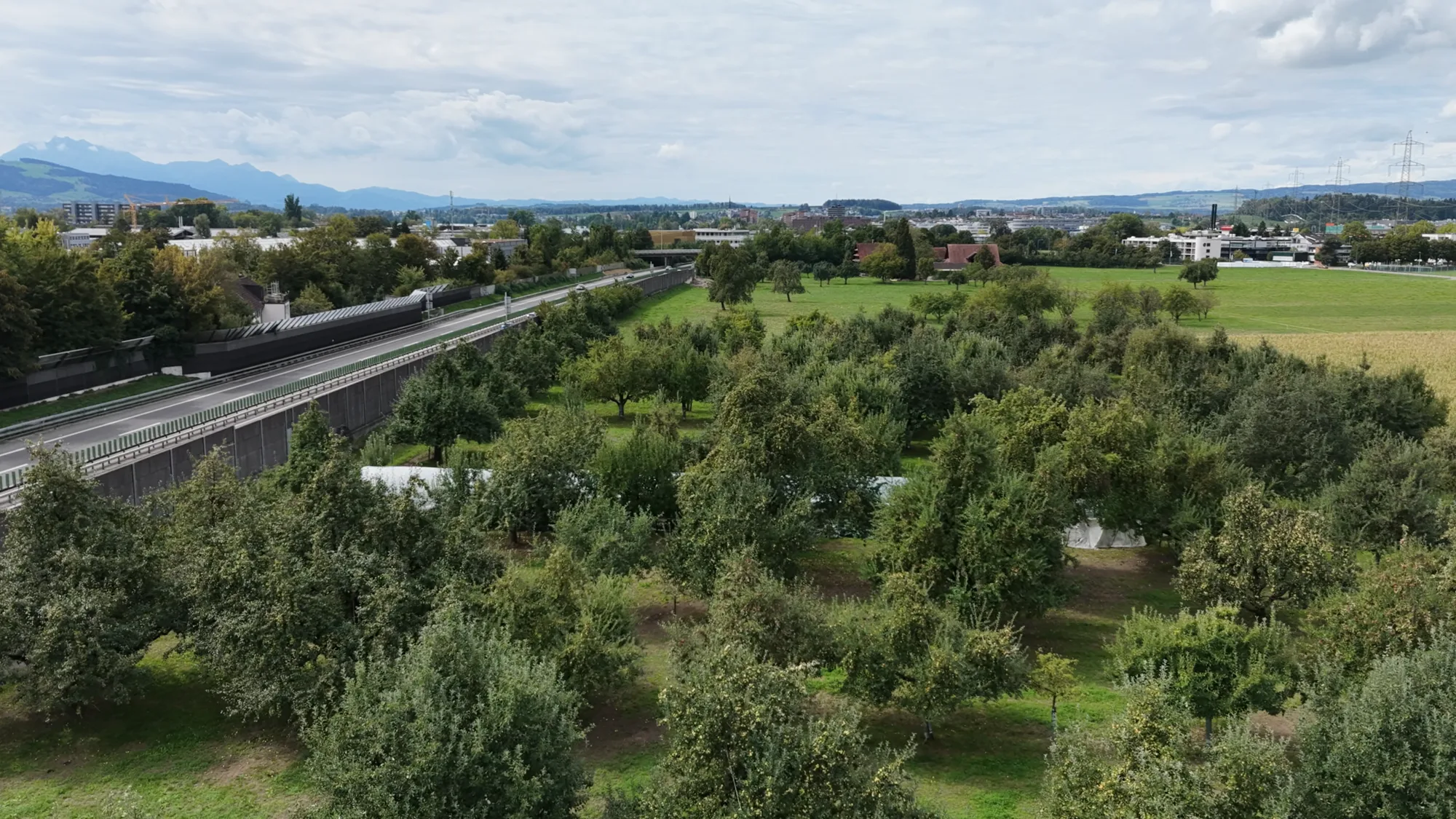 Luftaufnahme des Hofs mit Obstgarten und Autobahn